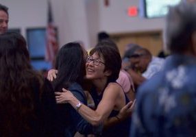 selective focus photography of two women hugging